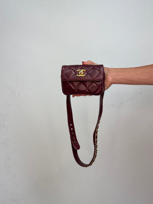 Chanel belt bag in burgundy quilted leather with a CC turnlock closure. Front of Bag