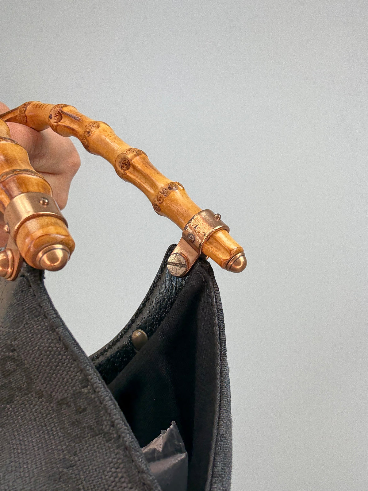 Gucci bag in black GG canvas with studded detailing and a bamboo handle.
Hardware Close-up