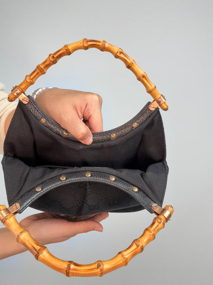 Gucci bag in black GG canvas with studded detailing and a bamboo handle. Inside of Bag
