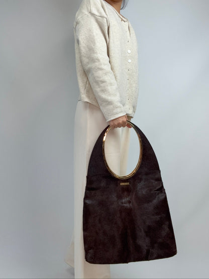 Gucci by Tom Ford oversized shoulder bag in brown pony hair from the Fall/Winter 1996 runway collection. Handheld on Model