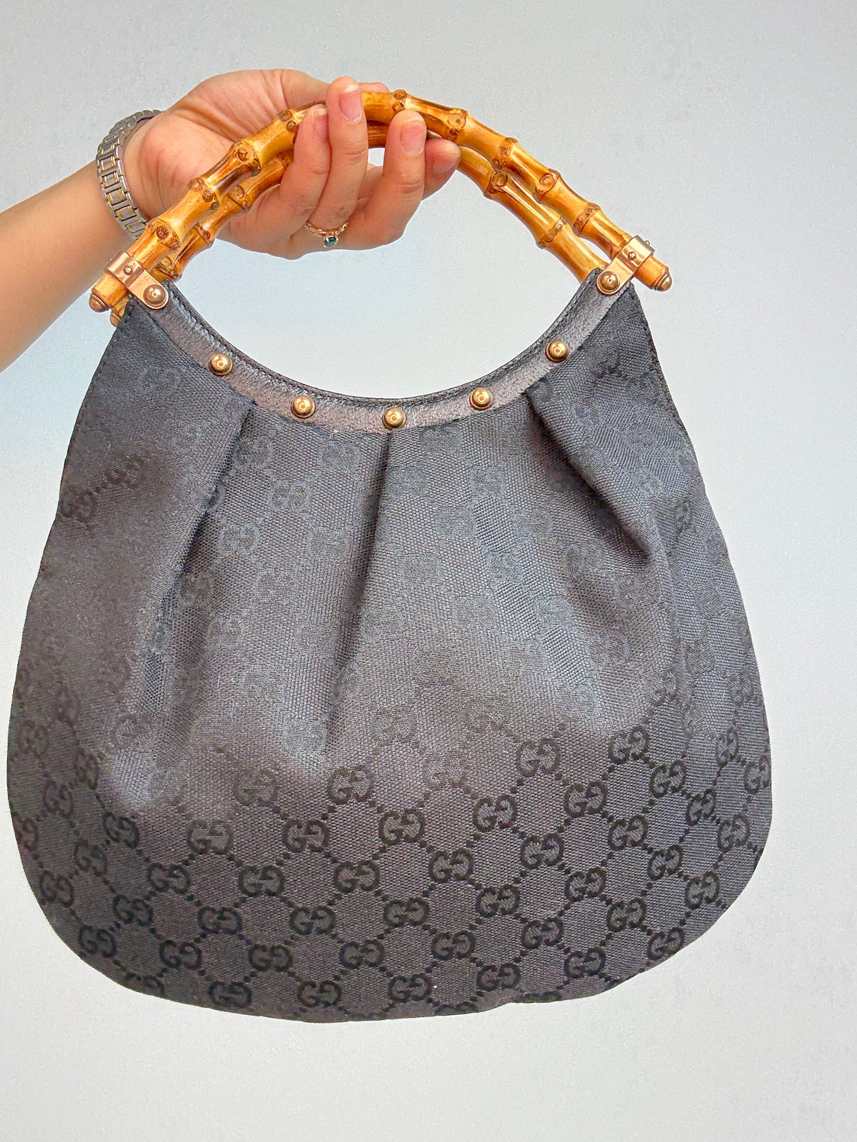Gucci bag in black GG canvas with studded detailing and a bamboo handle. Back of Bag
