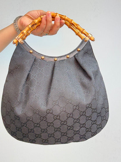 Gucci bag in black GG canvas with studded detailing and a bamboo handle. Back of Bag
